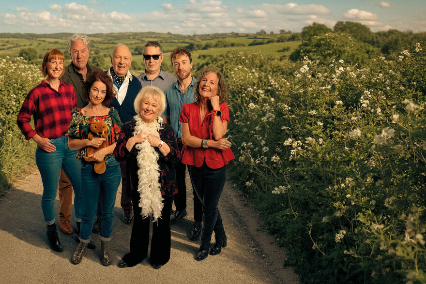 A group of people stand in a country lane 