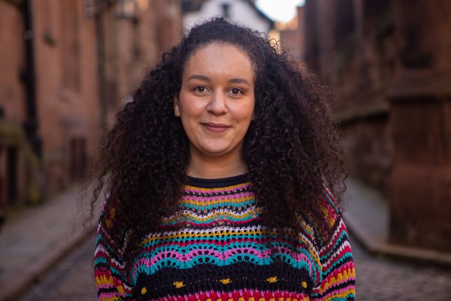 A portrait of Jenine Martin smiling outdoors.