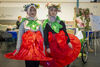 Two young women in matching costumes designed to look like flowers standing side-by-side at an event during People's Day.