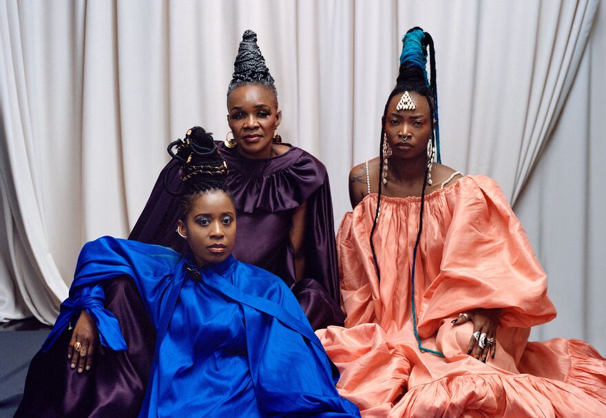 Three members of Les Amazones d'Afrique sat on the floor