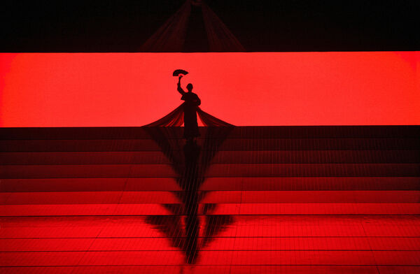 A silhouette of a geisha against a deep red backdrop.