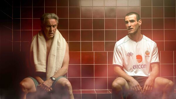 Two men sit together in a sauna. 