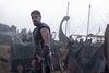 Matt Damon as Odysseus surrounded by boats on a beach. 