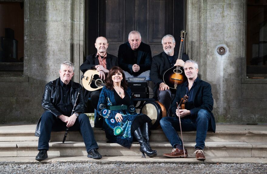 Group sat on stairs holding instruments