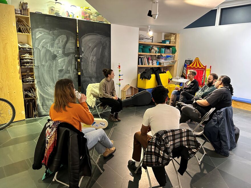 A group sat in a circle on chairs in Creative learning space