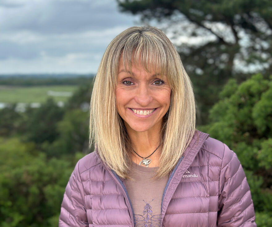 Michaela Strachan smiling in front of a view of the countryside