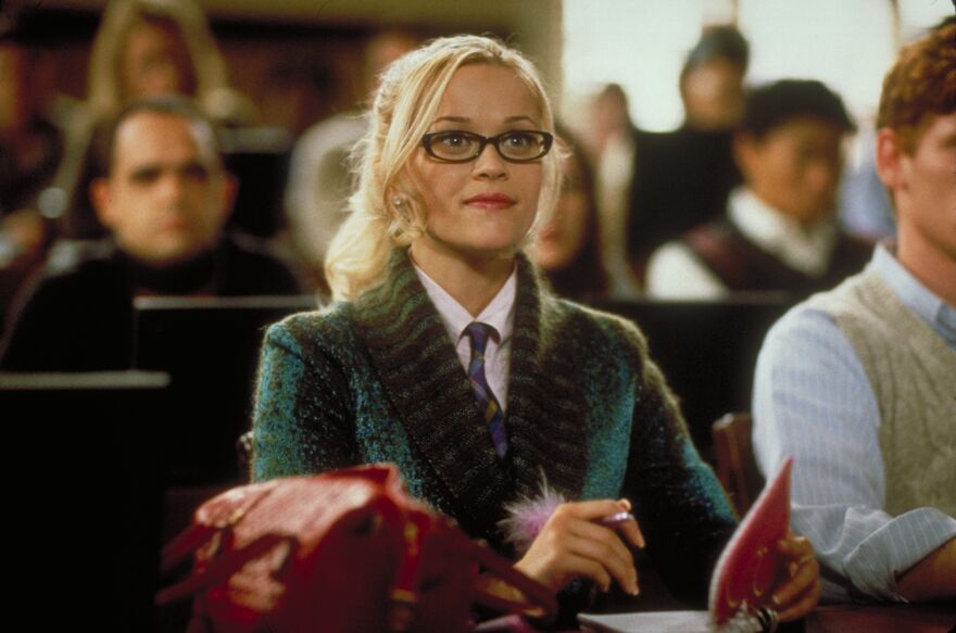 A young woman sits attentively in a lecture hall