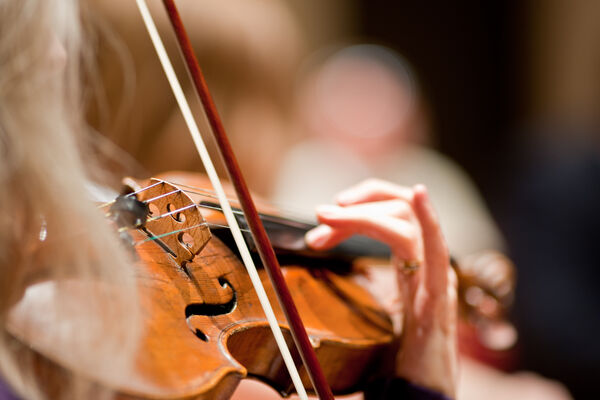 Close up image of person playing violin