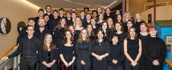 A chamber choir stood in rows on stairs