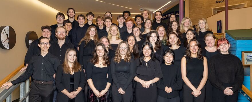 A chamber choir stood in rows on stairs