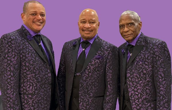 The Stylistics in black and purple suits on a purple background 