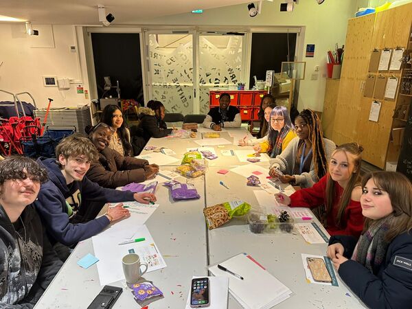 Group of young people sat around a table 
