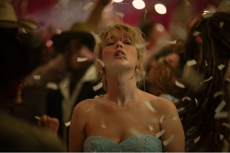 Jennifer Lawrence with her eyes closed looking up whilst confetti falls around her