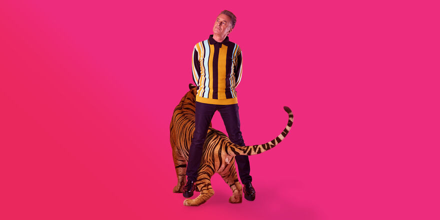 Chris Packaham with a tiger against a pink background