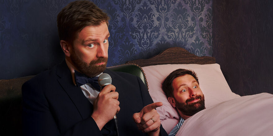 Pierre Novellie pointing with a microphone in the other hand with another Pierre Novellie tucked up in bed