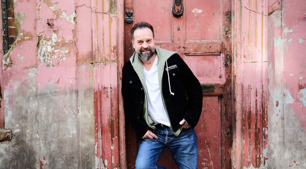 Alfie Boe leaning against an old wall