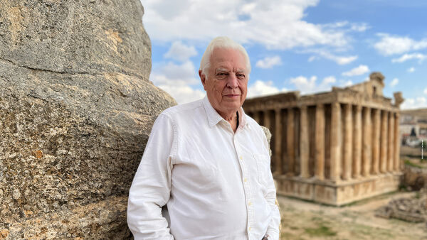 John Simpson standing in front of classical ruins