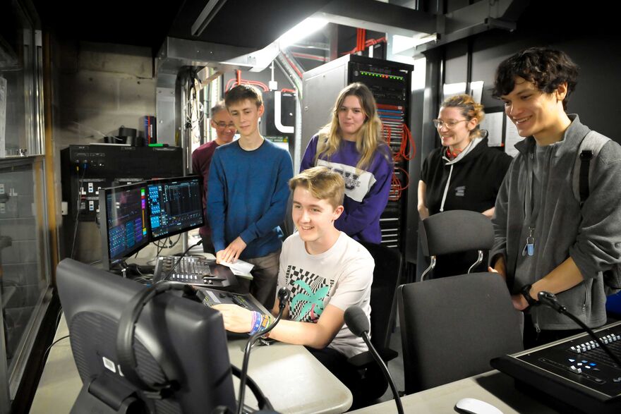 Students on a backstage tour interacting with a lighting desk
