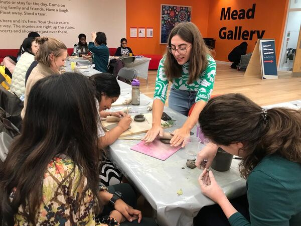 Emily Hett leading a clay workshop in gallery foyer space