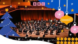 An orchestra on stage surrounding by Christmas illustrations