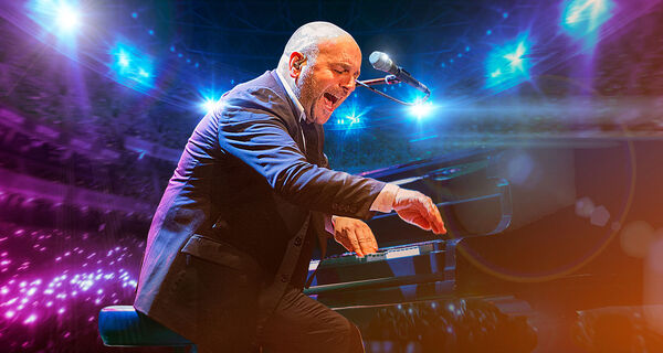 Elio Pace playing piano with a blurred audience and lights