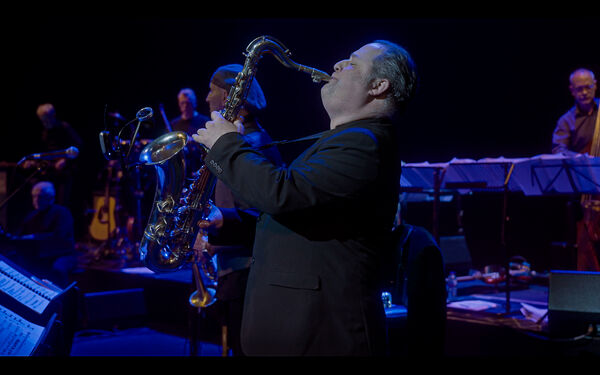 Man in suit playing the Saxophone 