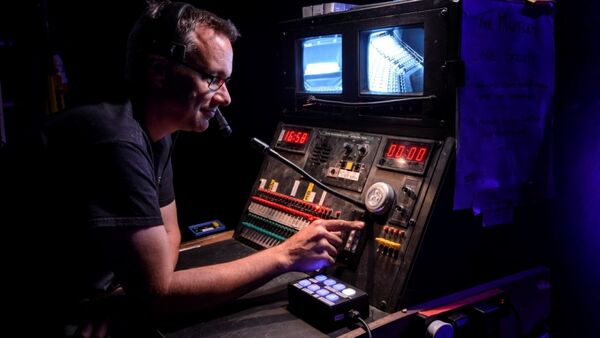 Man pushing button on audio/visual set-up