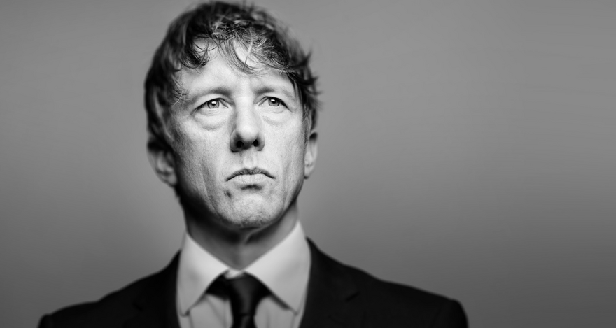 Jonathan Pie in a suit, image is in black and white