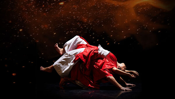 Two dancers with one laying on the other back in white and red robes 