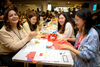 Students sat around a table doing origami 