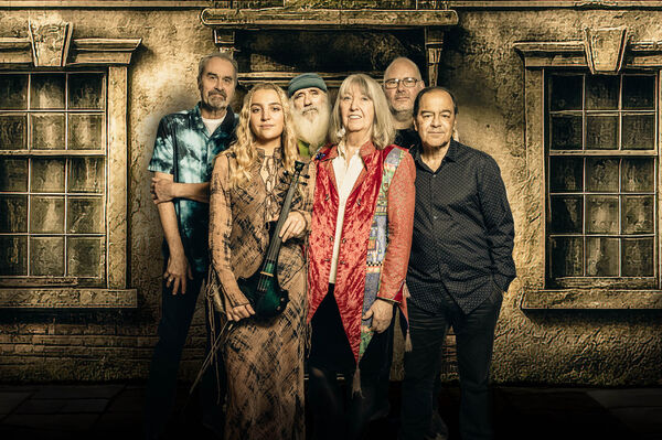 Steeleye Span stand together as a group with the ground floor of a beige house seen behind them Steeleye Span stand together as a group with the ground floor of a beige house seen behind them