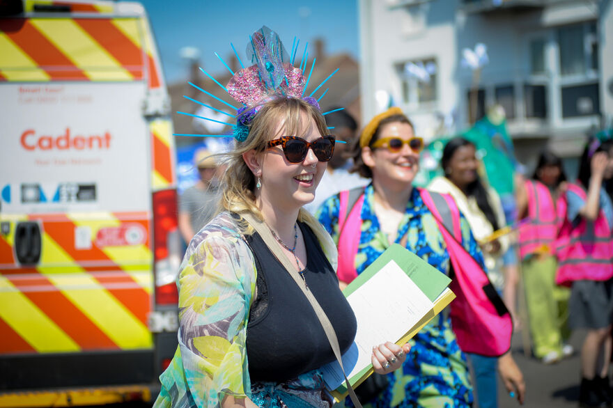 Sophie Welby wearing colourful clothes and head dress in the Canley parade