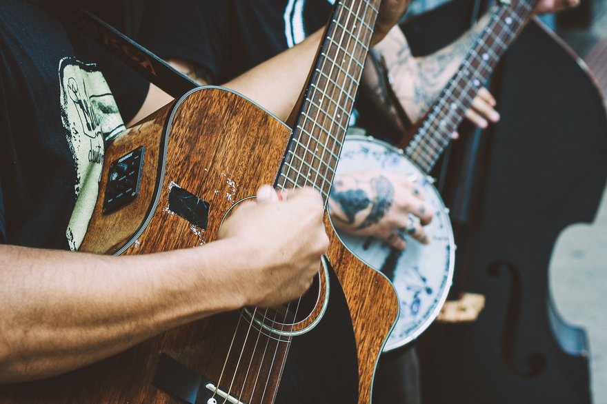 Zoomed in image of men playing a guitar and a banjo