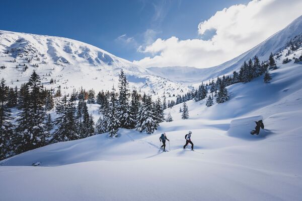 Two skiers on a snowy mountainside. Two skiers on a snowy mountainside.