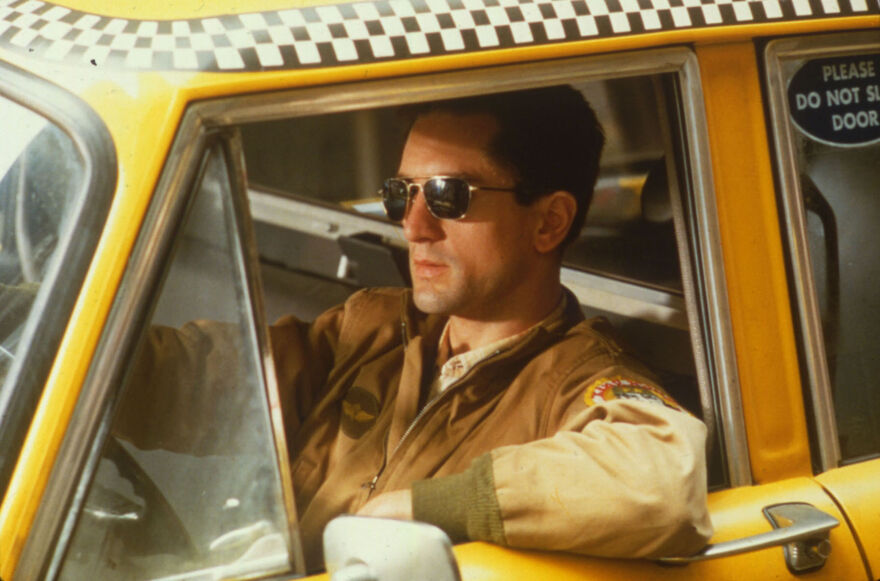 Robert De Niro as Travis Bickle in a yellow taxi cab. 