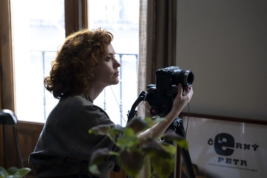 A young woman sets up a camera.