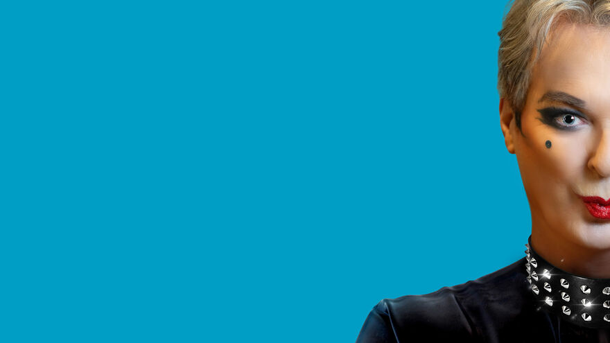 Bust of Julian Clary in leather with a blue background