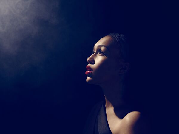 A woman in profile looking towards the light