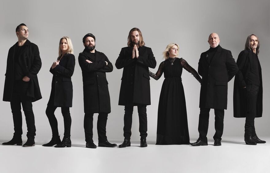 Tribute band Rumours of Fleetwood Mac dressed in black against a plain white studio backdrop.