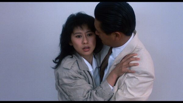 A woman holds onto a man tightly. A woman holds onto a man tightly.