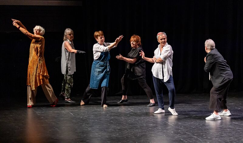 Elders dance performers on a stage holding poses