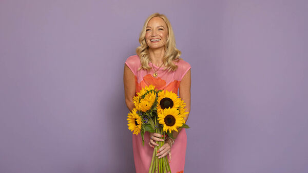 Donna Ashowrth holding smiling and holding sunflowers