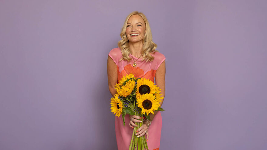 Donna Ashowrth holding smiling and holding sunflowers