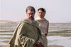 Matt Damon as Odysseus and Zendaya as Athena stand on a beach. 