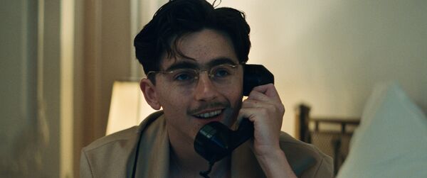 Timothée Chalamet as Marty Mauser. He smiles as he talks on the phone. Timothée Chalamet as Marty Mauser. He smiles as he talks on the phone.
