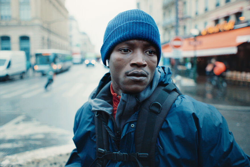 A young man stands in the middle of the road.