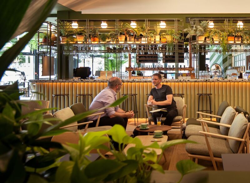 Two men sitting in Benugo talking