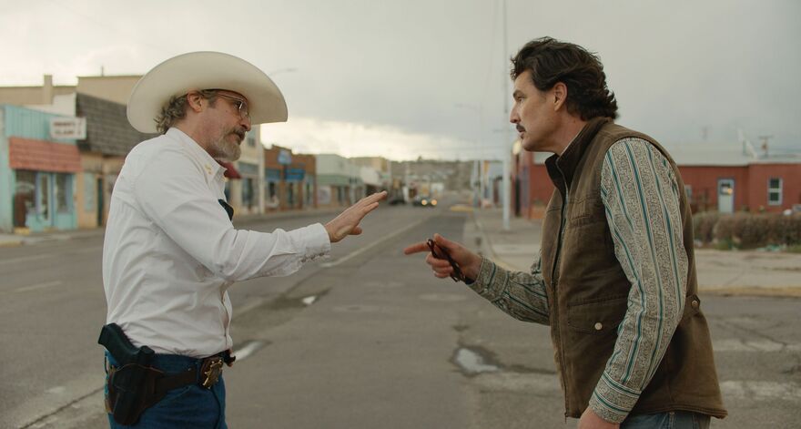 Two men confront one another in a small town street. 