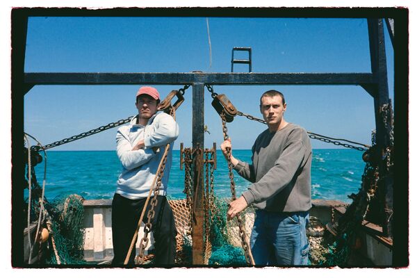 Two young men on a fishing boat. 