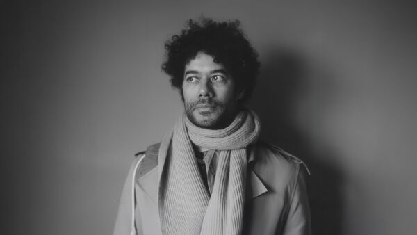Richard Ayoade in a scarf and coat image in black and white
